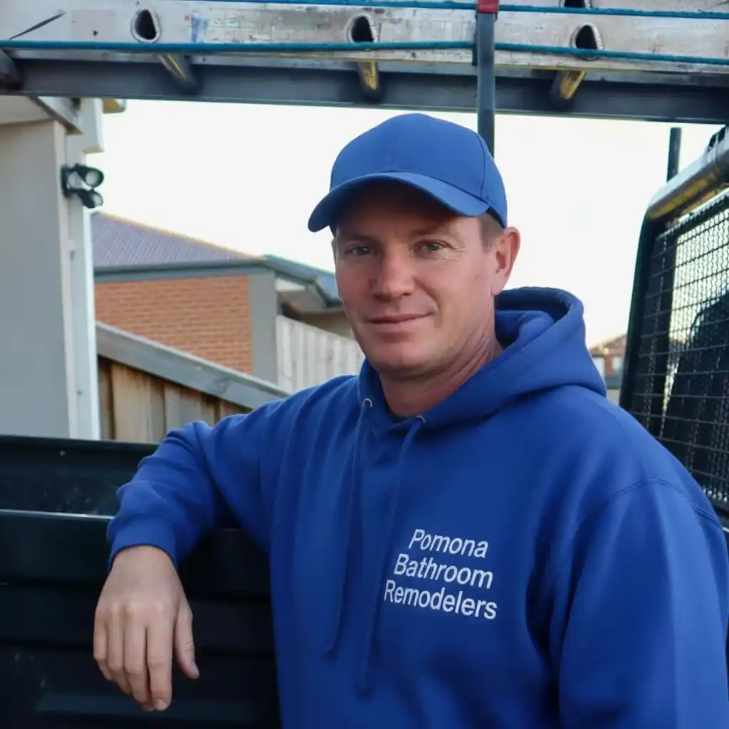 Randy Johnson, owner of Pomona Bathroom Remodelers, standing in front of company signage
